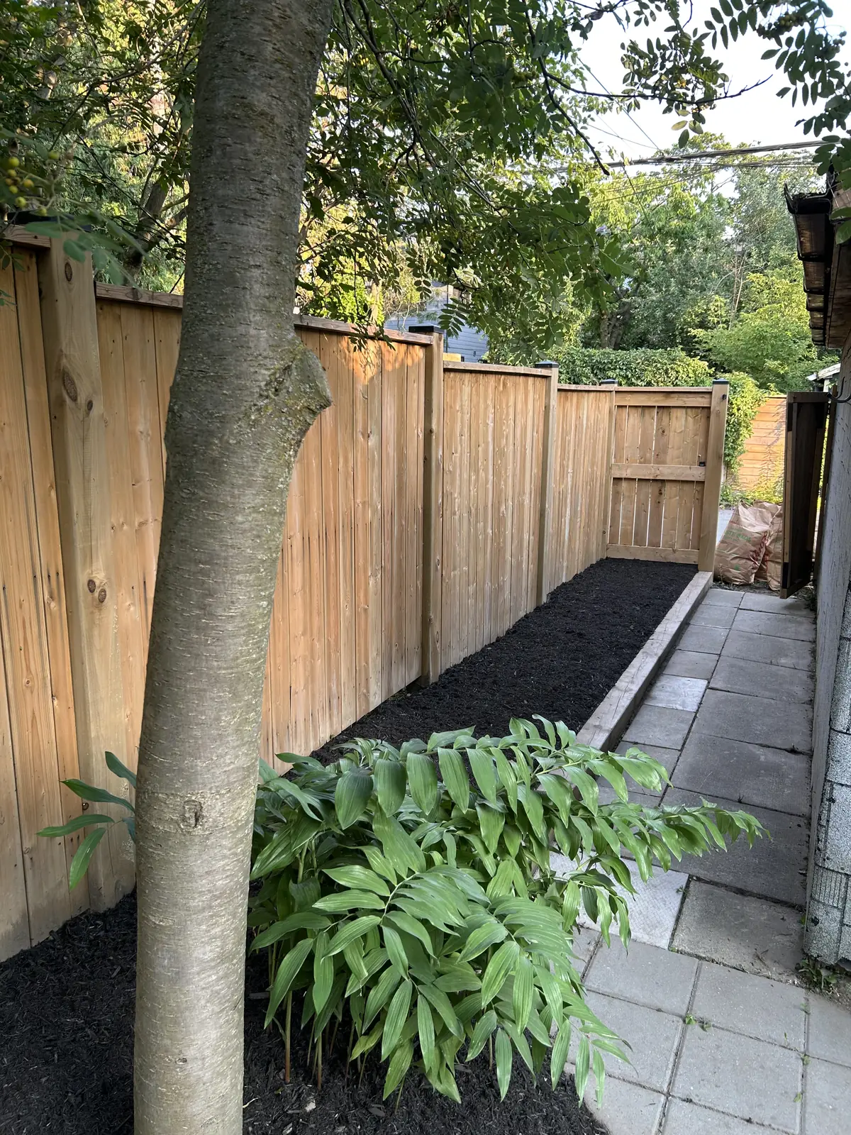 Freshly prepared garden bed along a wooden fence